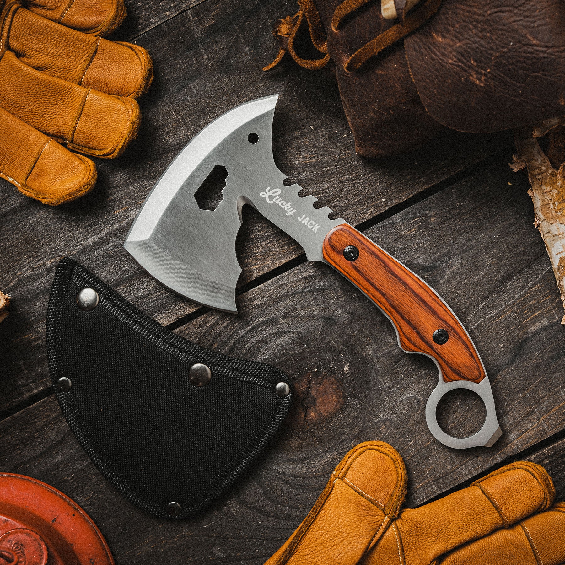 Small axe with wooden handle on a dark wooden surface with gloves and leather bag.